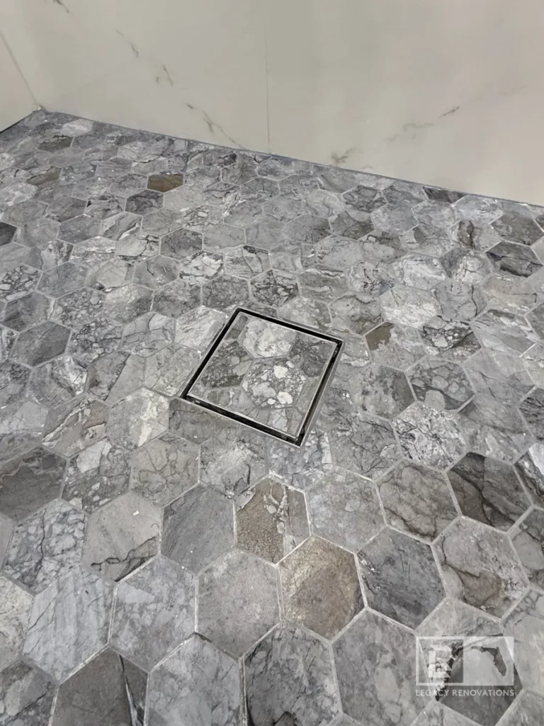 Bathroom vanity set against a backdrop of smooth, marble-patterned tiles, enhancing the modern black cabinetry in Autumn Green, Jacksonville, FL.