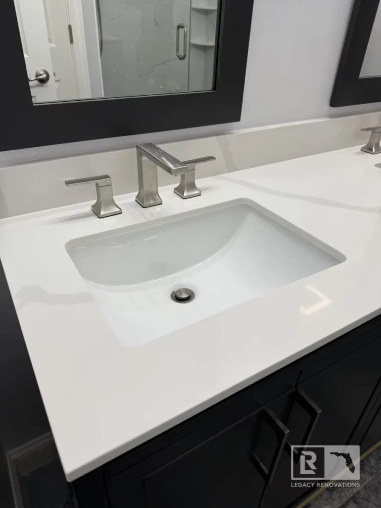 Modern vanity with white countertop, black cabinetry, and silver faucet in Autumn Green, Jacksonville, FL.