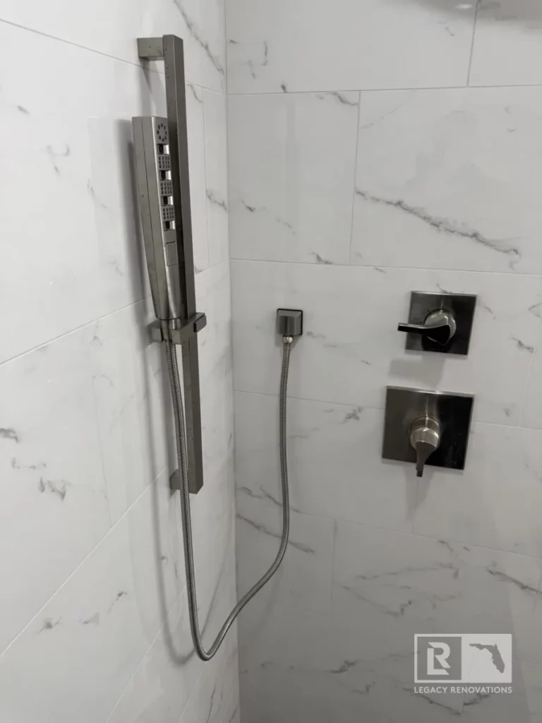 Close-up of a modern shower with white marble-style tiles