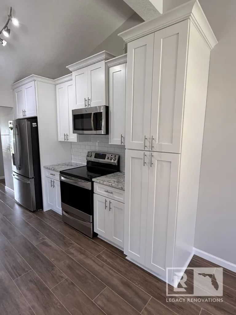 White subway tile backsplash and cabinetry with silver handles, creating a clean and timeless aesthetic.