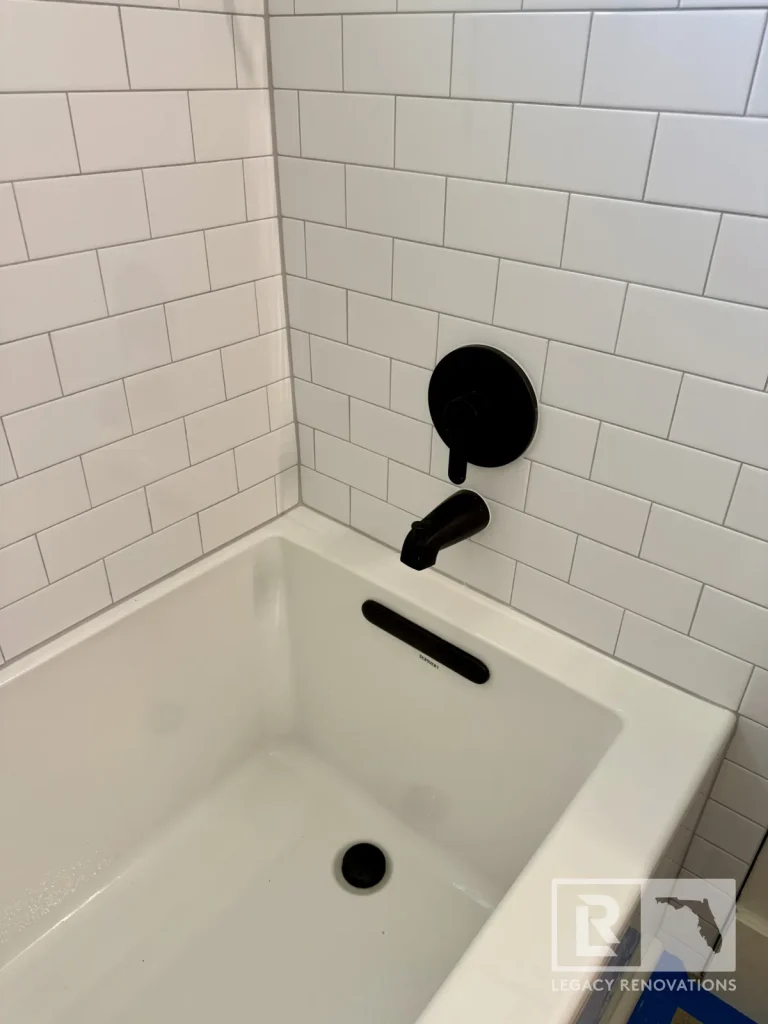 Alcove bathtub with matte black faucet, control, drain, and rectangular wall tile in Jacksonville, FL