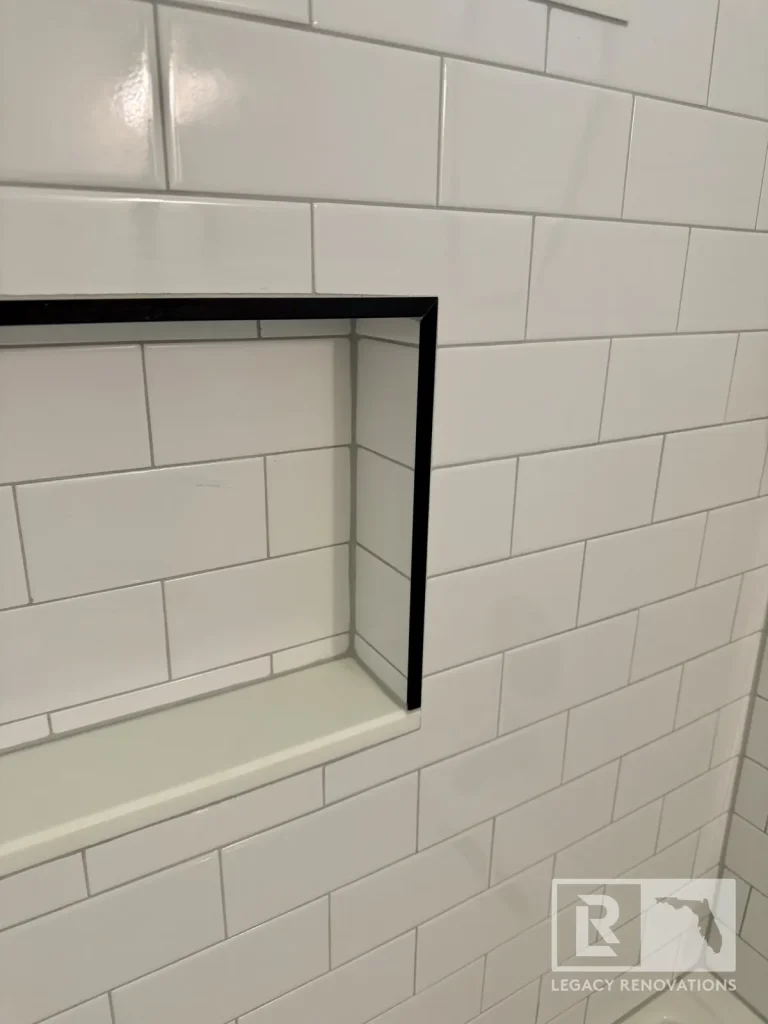 Recessed shower storage niche with black edging and rectangular wall tile in Jacksonville, FL