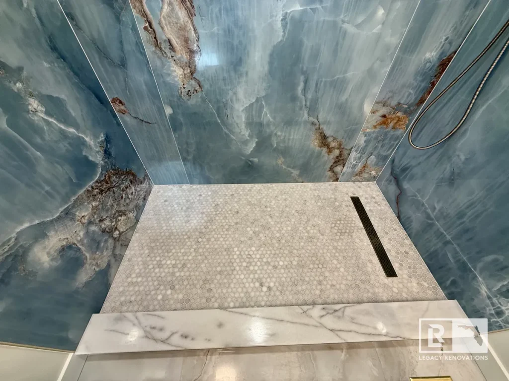 Luxury blue onyx walk-in shower with penny tile floor and linear drain in a custom bathroom remodel in Jacksonville, FL