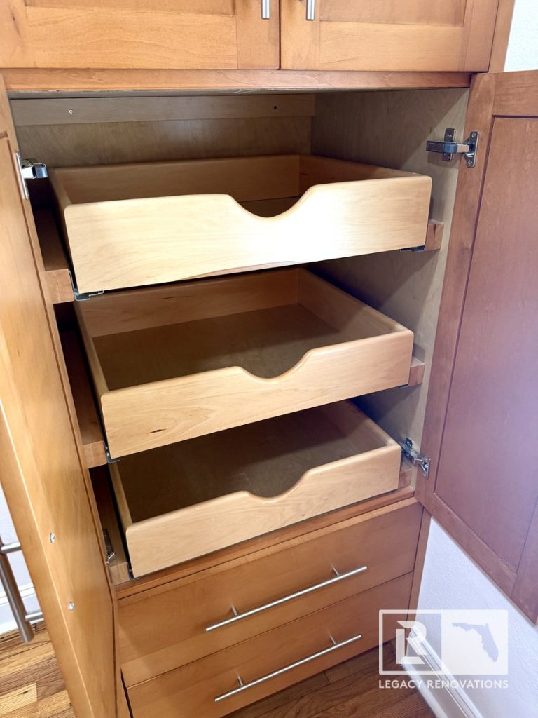 Kitchen remodel in Jacksonville, FL featuring a natural wood pantry cabinet with pull-out storage drawers, soft-close hardware, and built-in kitchen organization.