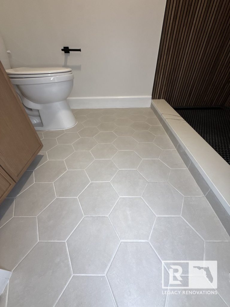 Modern bathroom remodel featuring light grey hexagonal floor tile and custom walk-in shower in Jacksonville, FL