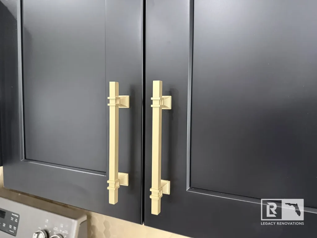 Matte black shaker cabinet doors featuring brushed gold T-bar handles.