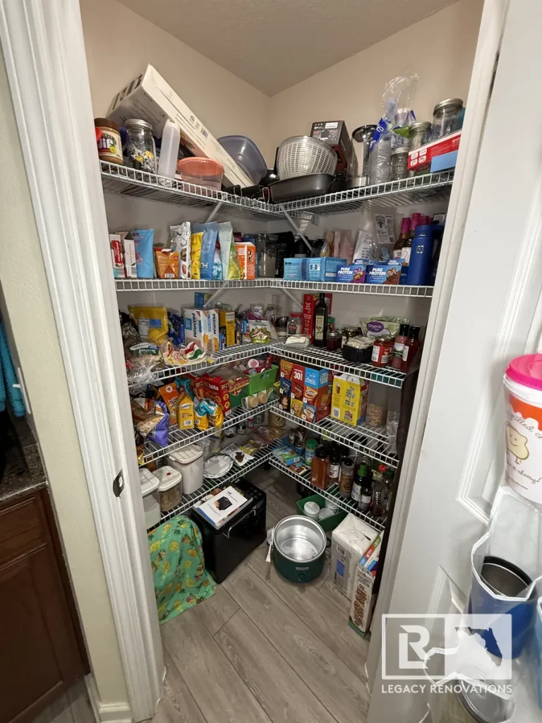 Interior view of a walk-in food pantry lined with white wire shelves and floor appliances in a Jacksonville FL home.